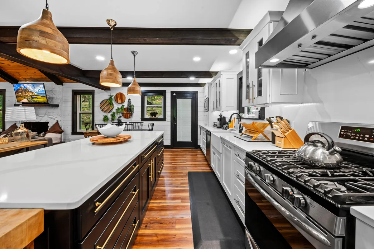 An inviting kitchen space centered around a generous island, with pendant lighting above, and prominent stainless steel appliances. The space is open and ideal for entertaining or casual family gatherings.